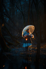 Girl with candle in the night forest