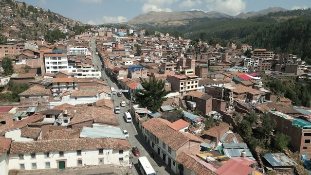 Cusco Cuzco Peru cityscape with traffic narrowed road of the city centre and traditional colonial building with mountains andes in background