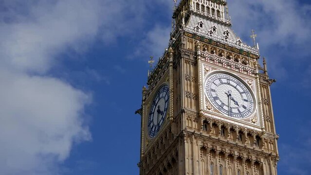 Low-angle shot of Big Ben clock tower on sunny day with beautiful clouds passing by following restoration.  British cultural icon. Tourist destination landmark in London, United Kingdom.