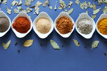 Seasonings of different flavors for cooking on a blue background with space for text. Preset for a...