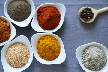 A variety of spice on a gray background. The concept is a gallery of flavors.