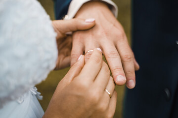 Obraz na płótnie Canvas bride puts on wedding ring to groom