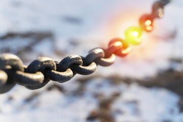black chain on a background of sunlight and snow, selective focus - Powered by Adobe