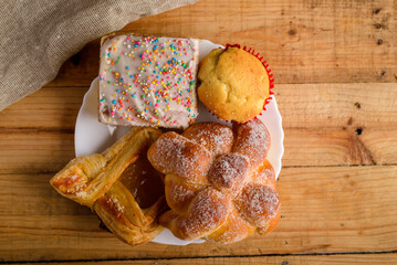 Pan de muerto and other sweet breads on a wooden table. Typical Mexican dessert.