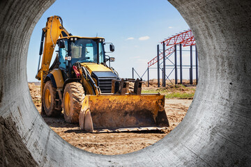 A large front loader transports crushed stone or gravel in a bucket at a construction site or...