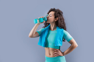 fitness woman with sport towel drink water in studio. fitness woman hold sport towel drink water