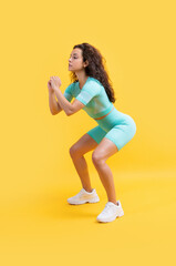 Fototapeta na wymiar fitness woman squatting in sportswear at studio. fitness woman in sportswear squatting
