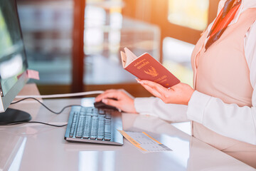 Thailand travel concept. Airline officer check in ticket Thai tourist with Passport Visa book at...