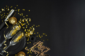 Dumbbell weight plate, golden decorations, confetti, champagne glasses, party streamers for New Year's Eve celebration. Gym workout resolution, Happy New Year flat lay composition with copy space.