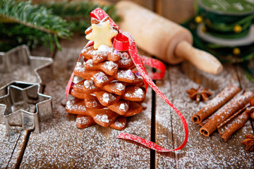 Home made baked Christmas gingerbread tree as a gift for family and friends on wooden background....