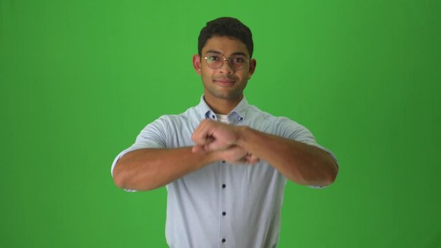 Male Signer Saying Good Night In Ecuadorian Sign Language Against Green Background. medium shot