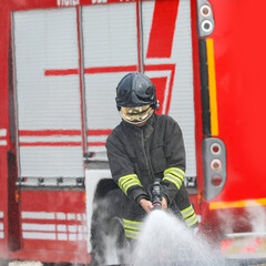 firefighter with helmet and protective visor while extinguishing a fire