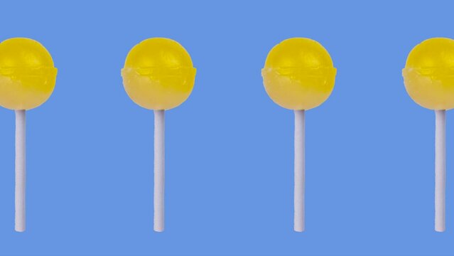 trendy food animation of a lot of yellow fruity lollipops on a blue background