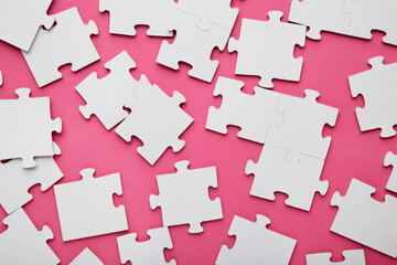 Close-up of a pile of uncompleted elements of a white puzzle. A huge number of rectangular pieces from one large white mosaic