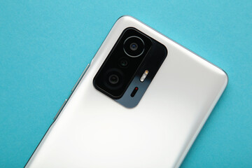 Mobile phone camera, flash lens on blue background.