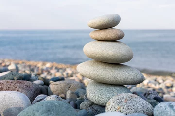 Fotobehang Stapel zen stenen in harmonie en balans met uitzicht op zee © fotogurmespb