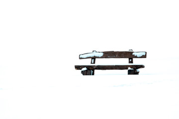 Simple image of a park bench in the snow