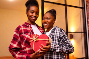 happy woman is making Valentine's Day gift to her beloved girlfriend at home at romantic night
