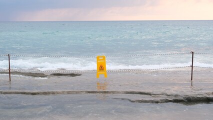 Slippery floor warning sign on the beach.