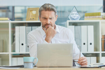 Businessman, laptop and thinking and confused in office for 404 error, internet glitch or financial...