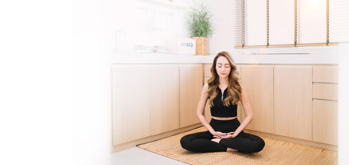 quiet yoga woman close eye in kitchen. beautiful asian female spiritual person determined meditating position in kitchen. calm focus gorgeous who determined to warm body spirit care on yoga mat