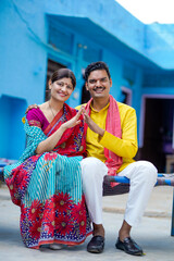 Obraz premium Happy Indian farmer with wife making home shape with hand. dream home concept.