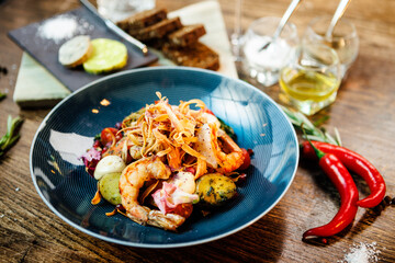 Warm salad with Argentinian king prawns. Almond potato, mini romaine lettuce, carrot, cherry tomato, pesto, black root chips, caramelized walnut, beet balsamic. Food served in modern restaurant