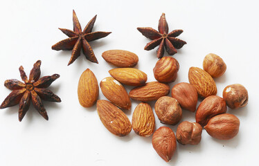 Star anis,  nuts and almonds on white background