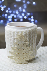 background for preparing for a Happy New Year and a Merry Christmas. winter holidays. decor. a white mug with tea on a background of bright bokeh.