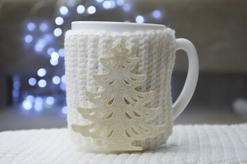 background for preparing for a Happy New Year and a Merry Christmas. winter holidays. decor. a white mug with tea on a background of bright bokeh.