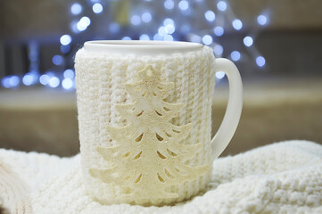 background for preparing for a Happy New Year and a Merry Christmas. winter holidays. decor. a white mug with tea on a background of bright bokeh.