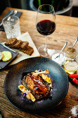 Corn chicken supreme. Beluga lentils, Old Ammerlander cheese, mini zucchini, red wine sauce. Delicious healthy traditional food closeup served for lunch in modern gourmet cuisine restaurant