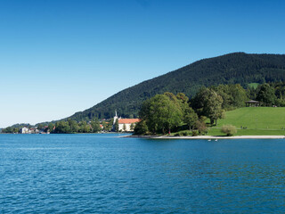 Tegernsee in Bavarian Alps. Promenade on the Shoreline of Rottach-Egern with view to the Benedictine monastery or Tergernsee Abbey tody a Schloss in Tegernsee