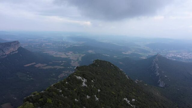 Top of a mountain if south of France Pic Saint Loup aerial shot along the crest cloudy day