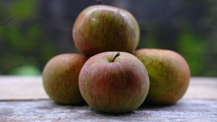 Pile of Green red apple fruits on wooden background 