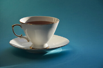 a white mug with tea on a saucer. background for the design.