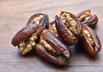 fresh dates with walnuts inside on a wooden table