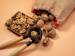 Walnut and nutcracker on orange background. Raw walnut.