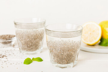Healthy breakfast or morning with chia seeds lemon and mint on table background, vegetarian food, diet and health concept. Chia pudding with lemon and mint