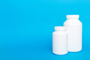 supplement pills with medicine bottle health care and medical top view. Vitamin tablets. Top view mockup bottle for pills and vitamins with green leaves, natural organic bio supplement, copy space