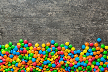 Mixed collection of colorful candy, on colored background. Flat lay, top view. frame of colorful chocolate coated candy