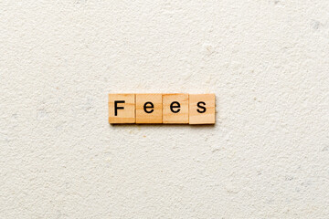 Fees word written on wood block. Fees text on cement table for your desing, Top view concept