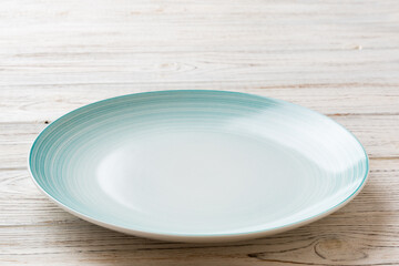 Perspective view of empty blue plate on wooden background. Empty space for your design