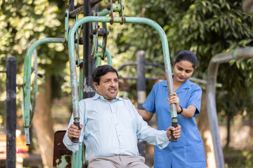 Fototapeta na wymiar A physiotherapist or professional caregiver watches closely as a senior adult woman exercises on an outdoor gym.