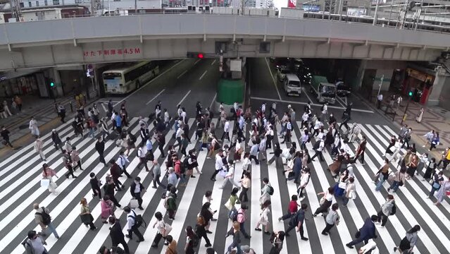 OSAKA, JAPAN : Aerial high angle view of crowd of people walking at zebra crossing and train near Osaka station. Commuters at busy rush hour. Japanese lifestyle and business concept. Time lapse shot.