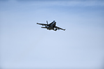 Military supersonic fighter jet with blue sky in the background