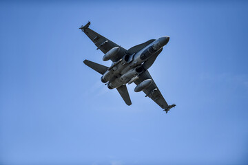Military supersonic fighter jet with blue sky in the background