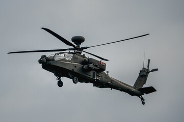 close up of a British army AH-64E Boeing Apache Attack helicopter (ZM722 ArmyAir606) on landing approach, autumn sky