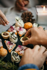 Close up image of a plate of appetizer served outdoors at a garden party.  A hands taking delicious appetizers.