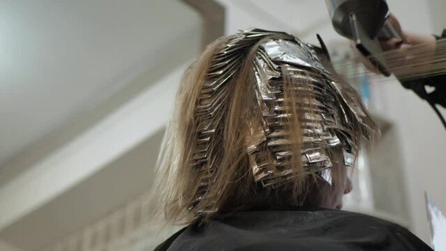Dry female hair, copy space. Hair stylist uses hair dryer in beauty salon, closeup